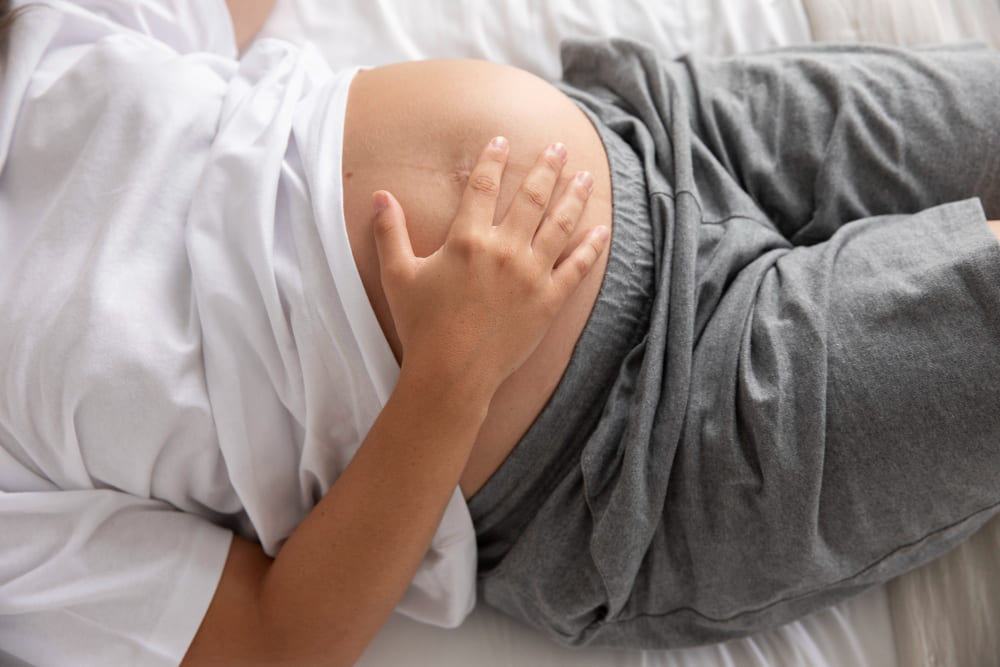 mujer embarazada frotando su panza